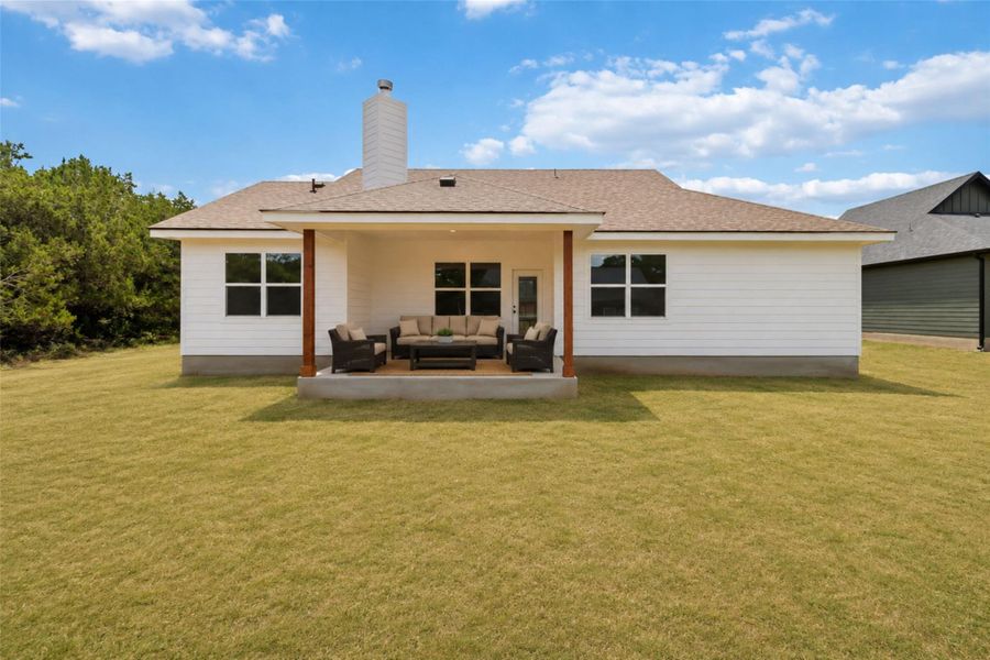 Back of home with virtually staged patio and green color added to the grass