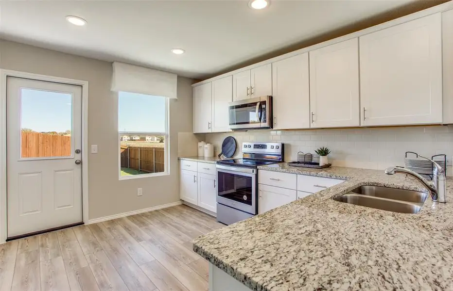 High-end gourmet kitchen with premium finishes and upgraded appliances *Model representation