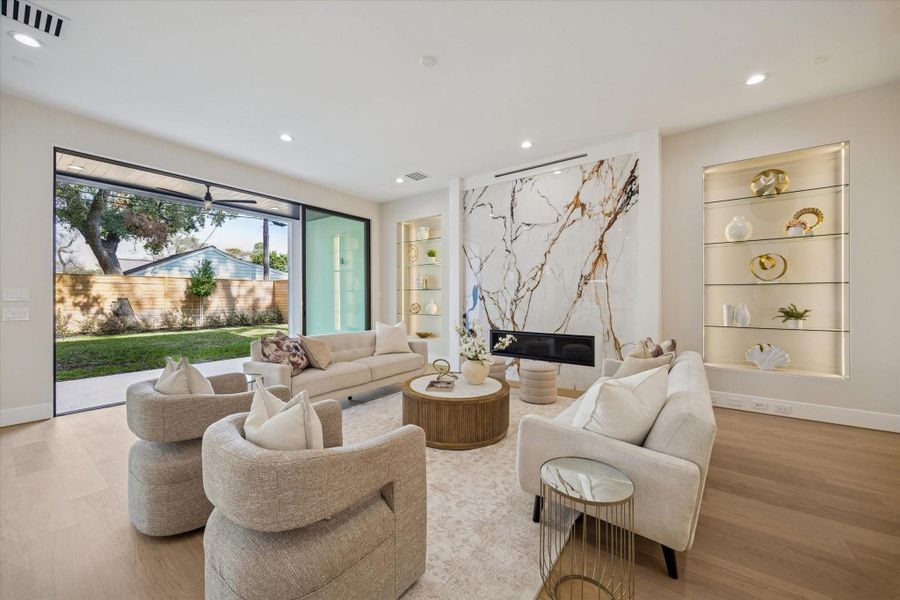 The living area flows into the kitchen, with stacking sliding glass doors leading to the patio and inviting natural light inside. This airy layout creates an ideal backdrop for everyday living as well as entertaining, allowing conversation to carry easily from indoors to out.
