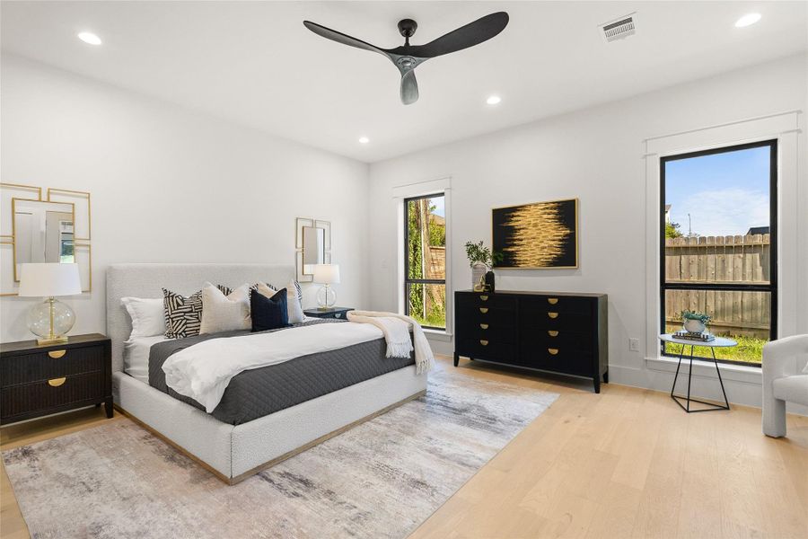 Waking up feels effortless in your spacious primary bedroom, where oversized windows and clean modern finishes create a bright, relaxing escape.