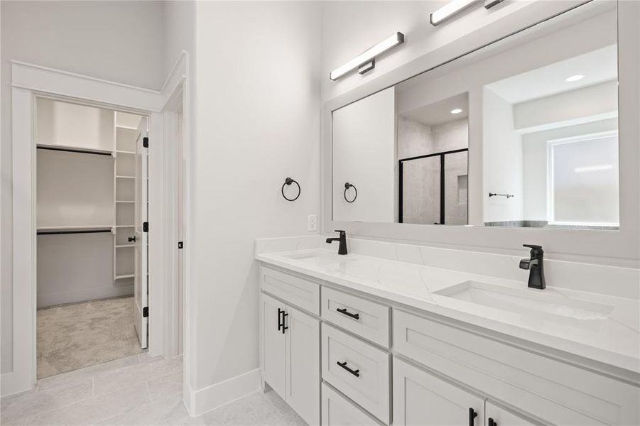 Dual vanity with integrated sinks, white cabinetry, and matte black hardware