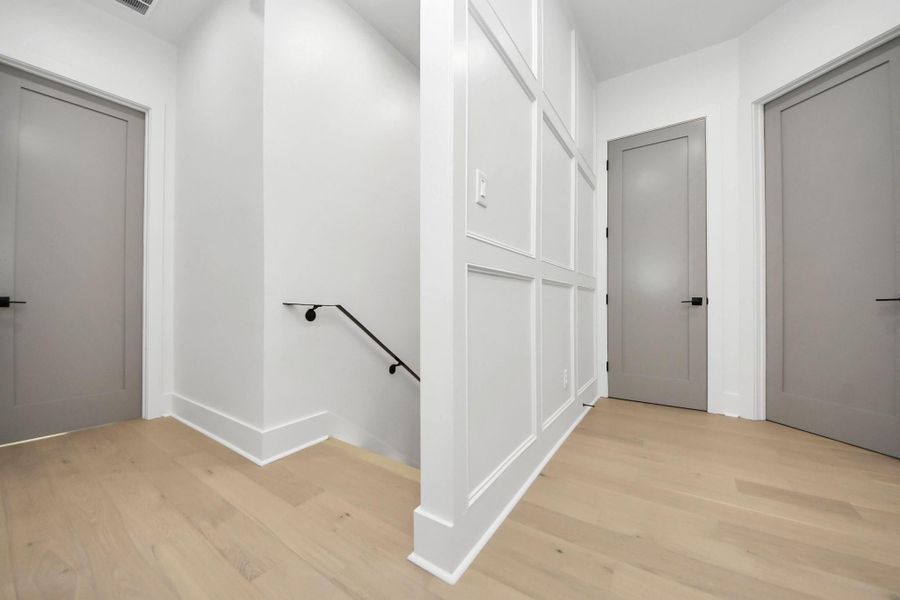 Upstairs, the elegance continues with a stunning accent wall, complemented by gray doors that provide beautiful contrast, enhanced by Emtek line hardware door levers. Upstairs, the elegance continues with a stunning accent wall, complemented by gray doors that provide beautiful contrast, enhanced by Emtek line hardware door levers.