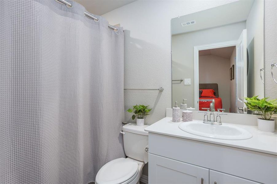 Bathroom with vanity and a shower with shower curtain Bathroom with vanity and a shower with shower curtain