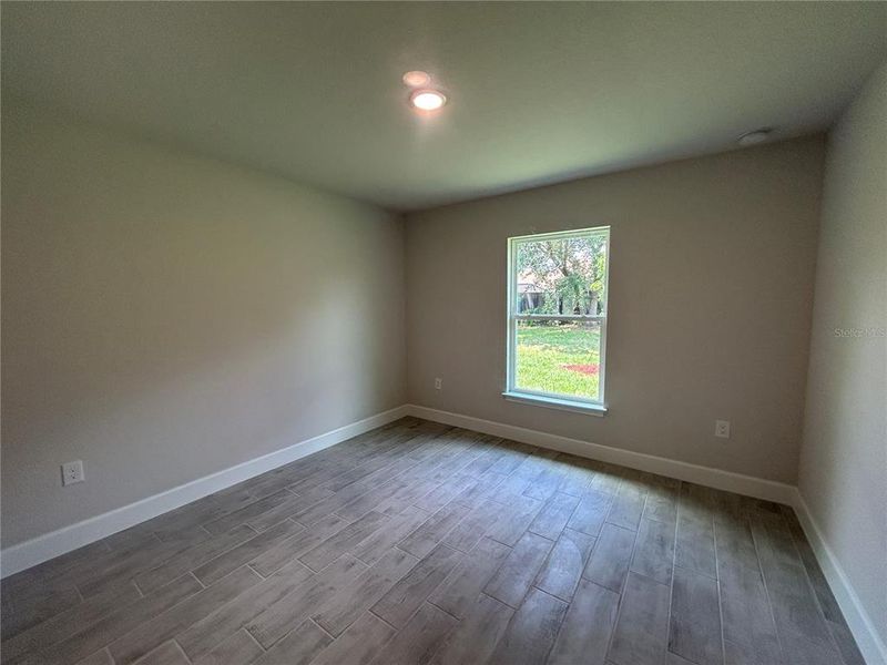 2nd Bedroom with Wood Look Ceramic Tile Plank Flooring 2nd Bedroom with Wood Look Ceramic Tile Plank Flooring