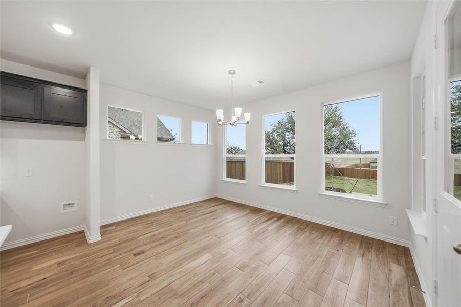 Unfurnished dining area with light wood-style floors and a chandelier