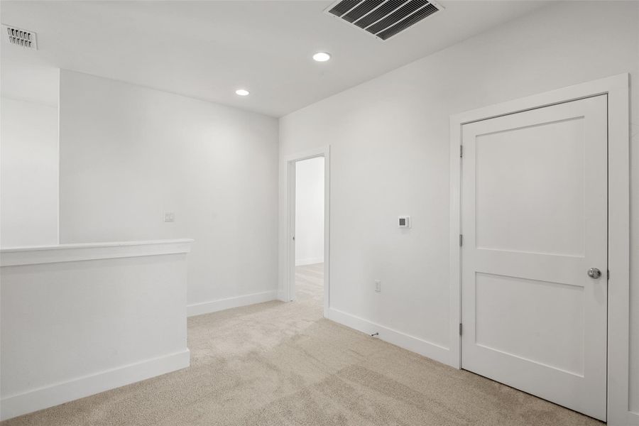 Spare room with light carpet and recessed lighting
