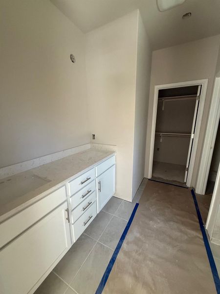 Bathroom featuring tile patterned floors and a walk in closet