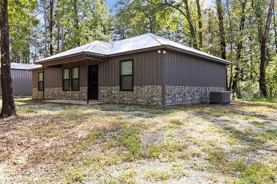 View of side of property featuring stone metal siding View of side of property featuring stone metal siding