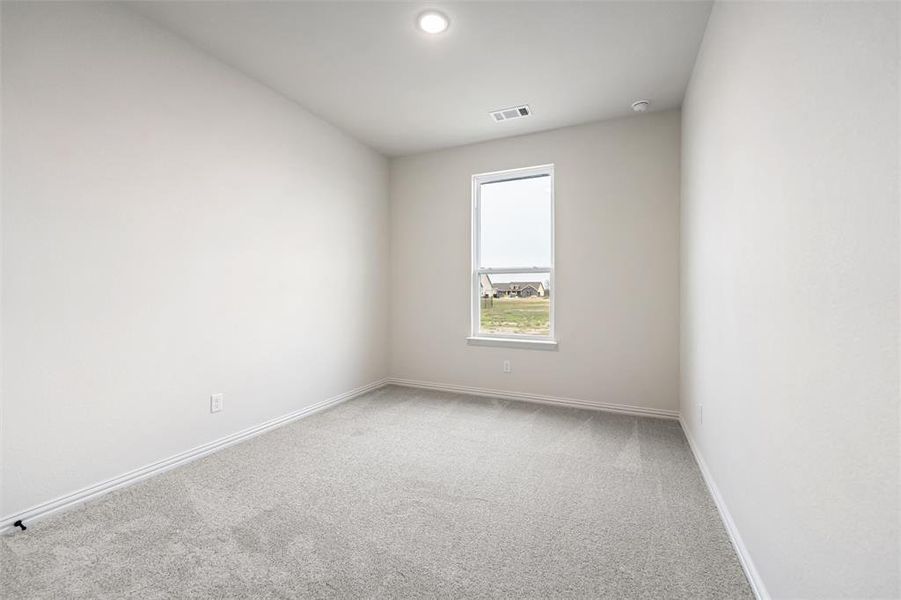 Empty room featuring light colored carpet and baseboards