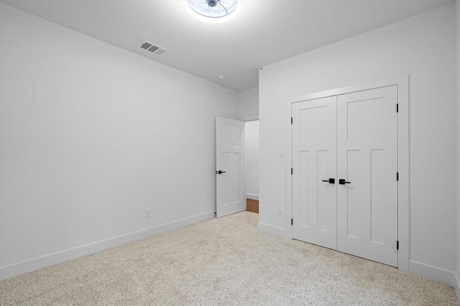 Unfurnished bedroom with carpet flooring and a closet Unfurnished bedroom with carpet flooring and a closet