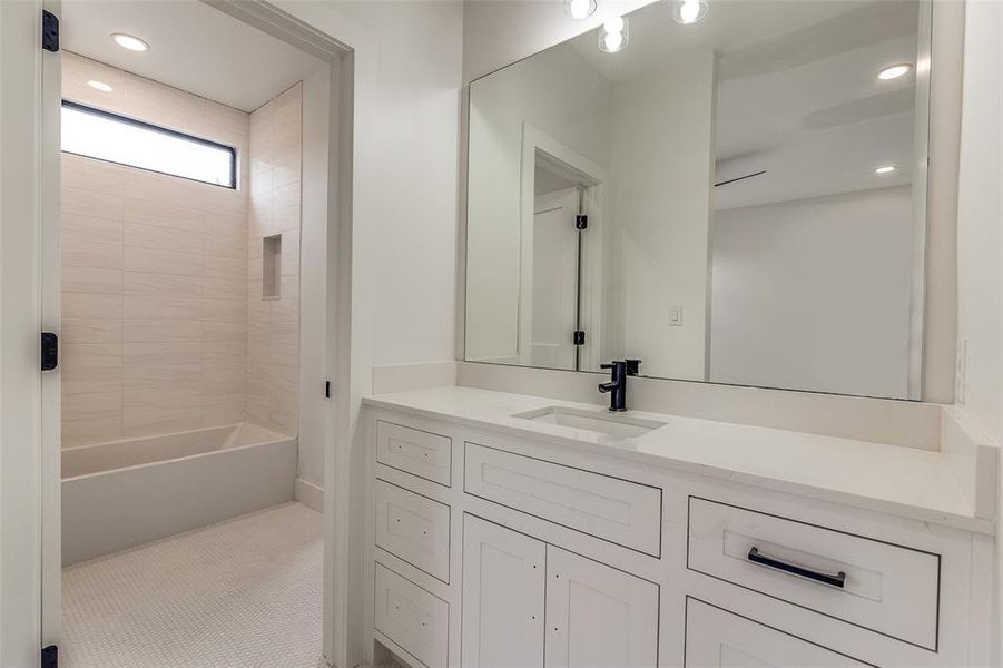 Bathroom featuring tile patterned floors, vanity, and tub / shower combination