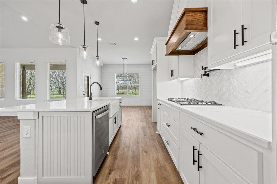 Kitchen featuring light wood-style flooring, white cabinets, a center island with sink, stainless steel appliances, and recessed lighting Kitchen featuring light wood-style flooring, white cabinets, a center island with sink, stainless steel appliances, and recessed lighting