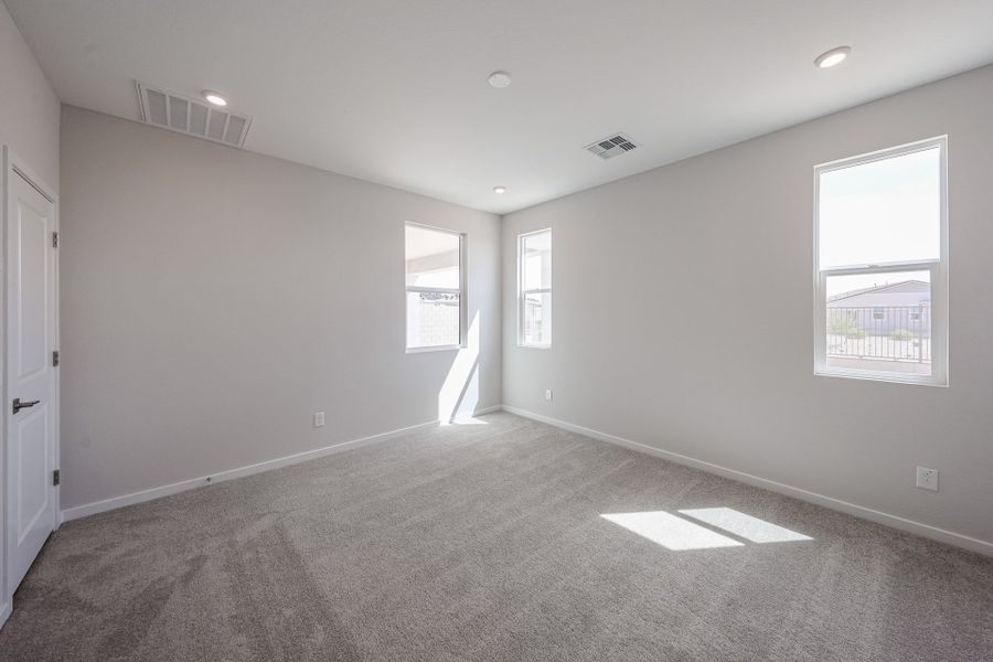 A room with a carpet and windows.