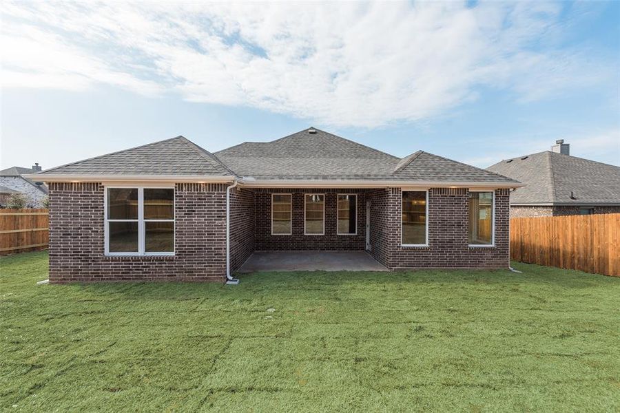 Rear view of property with a patio and a lawn