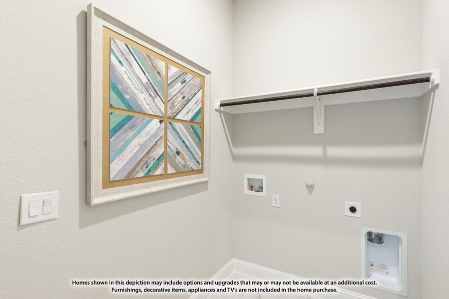 Laundry room with white wall shelf, washer hookups, and decorative framed artwork on the wall. Laundry room with white wall shelf, washer hookups, and decorative framed artwork on the wall.