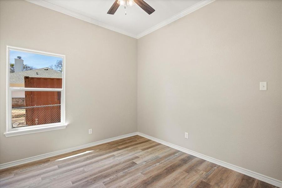 Unfurnished room with crown molding, light wood-style flooring, and ceiling fan