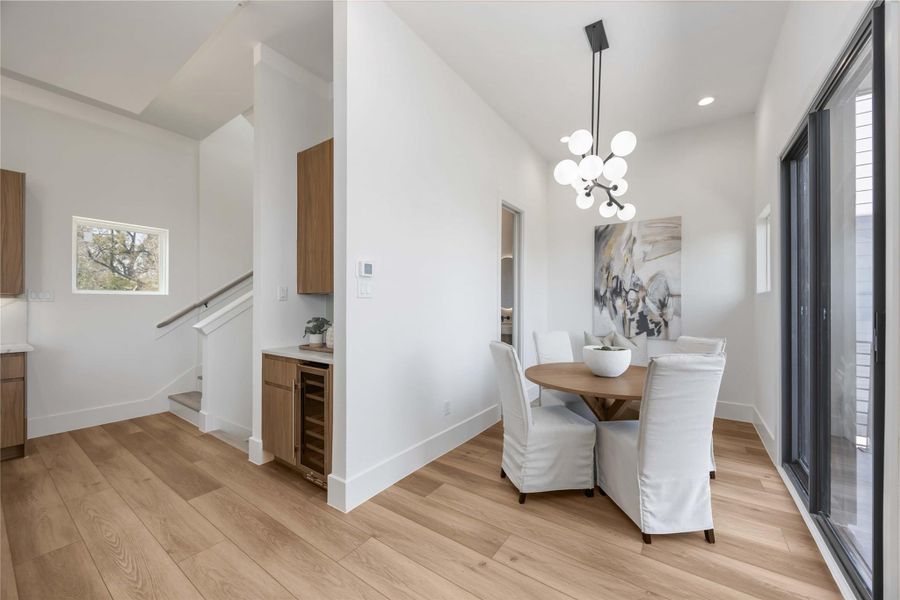 The dining area sits adjacent to the dry bar and overlooks the balcony.