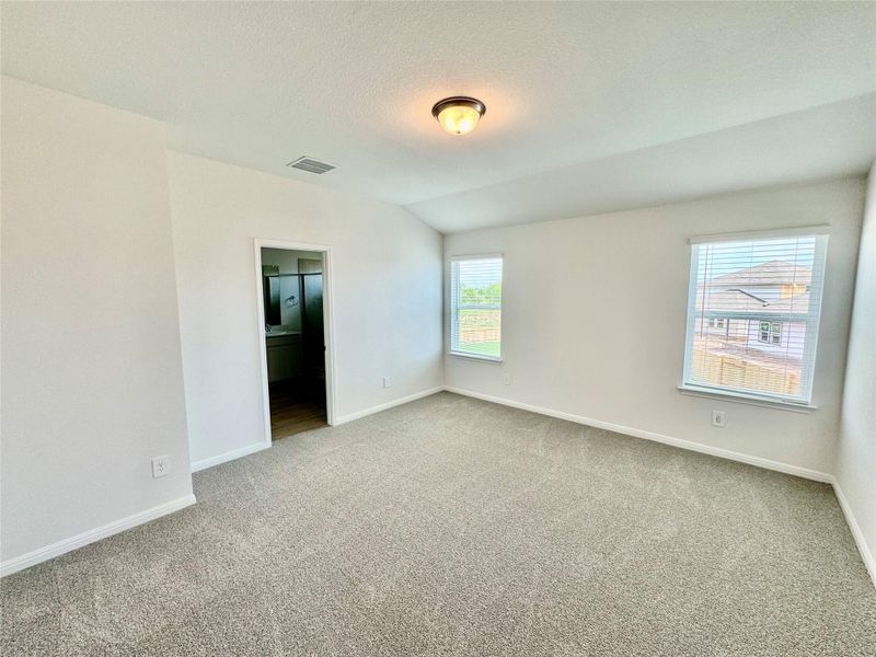 Unfurnished room with carpet floors, lofted ceiling, and a textured ceiling Unfurnished room with carpet floors, lofted ceiling, and a textured ceiling