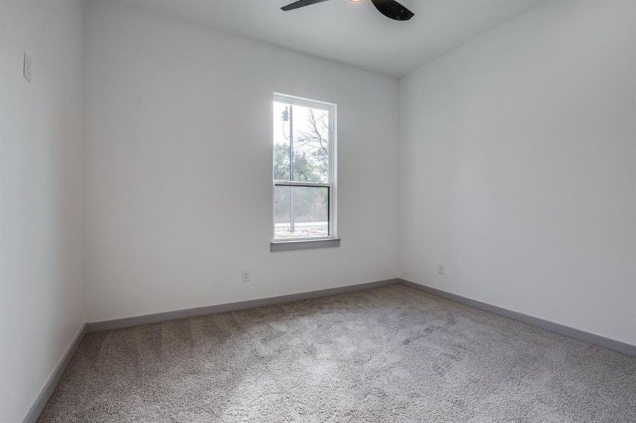 Spare room featuring ceiling fan and carpet floors