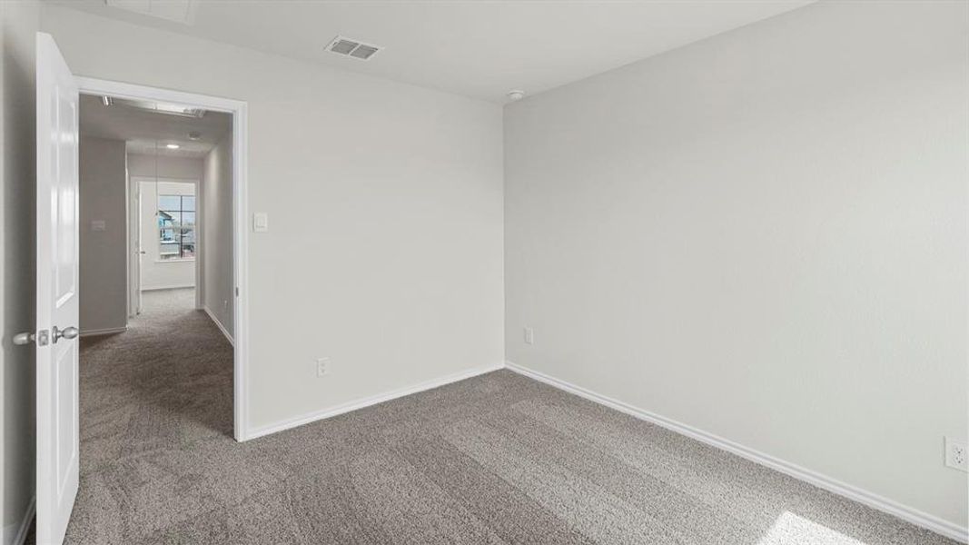 The room features light gray walls and plush gray carpeting