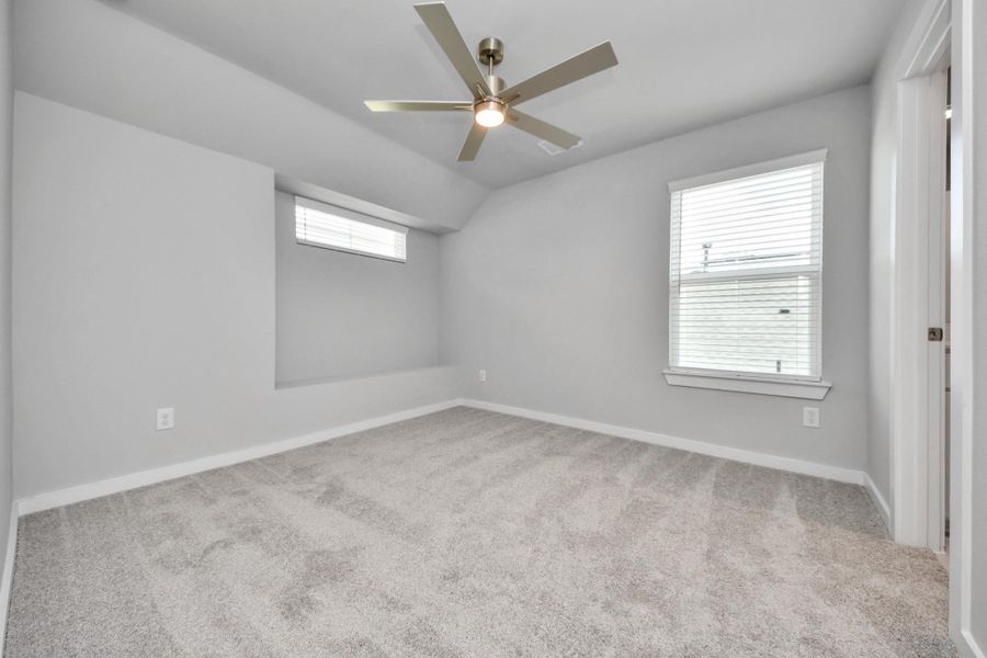 Secondary bedroom features plush carpeting, large windows that let in plenty of natural light, bright paint, and spacious closets.