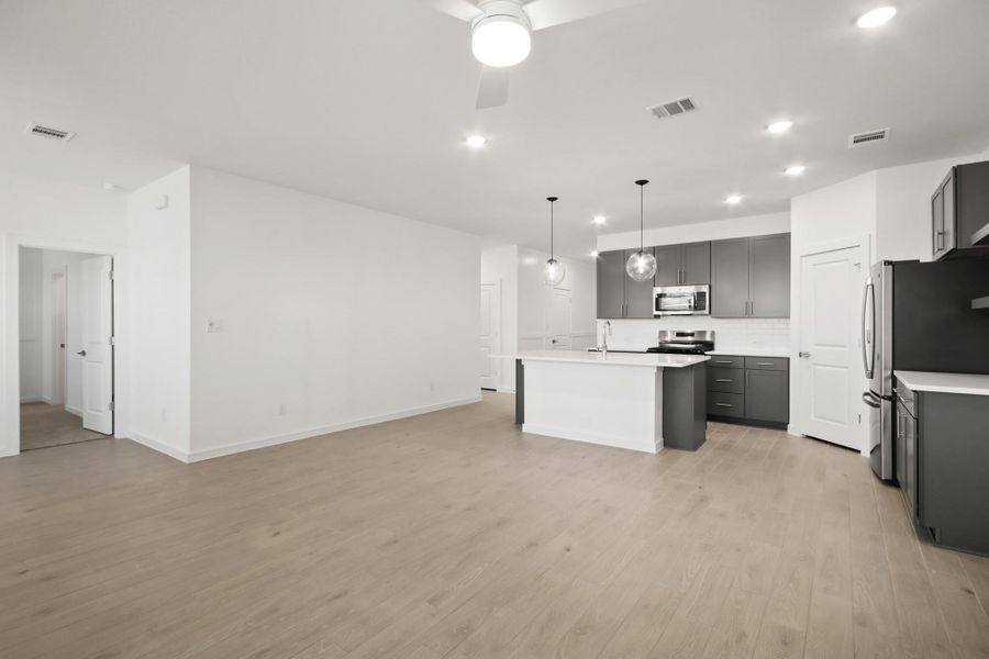 Kitchen open to the great room and dining area (*Photo not of actual home and used for illustration purposes only.)