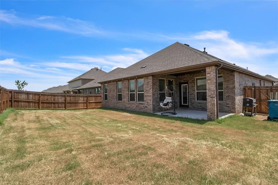 Back of house with a lawn and a patio area