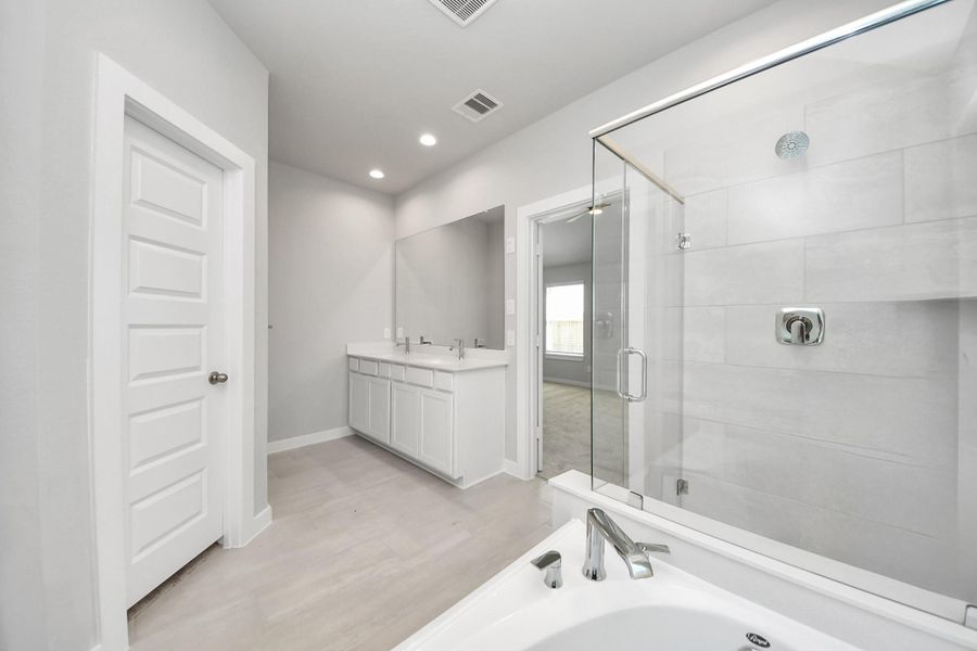 This additional view of the primary bath features a walk-in shower with the tile surround and separate garden tub perfect for soaking after a long day. Sample photo of completed home with similar floor plan. Actual colors and selections may vary. This additional view of the primary bath features a walk-in shower with the tile surround and separate garden tub perfect for soaking after a long day. Sample photo of completed home with similar floor plan. Actual colors and selections may vary.