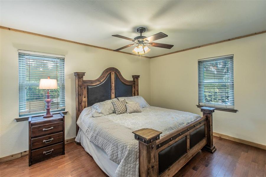 Comfortable primary suite with hardwood floors and peaceful views of the surrounding property. Comfortable primary suite with hardwood floors and peaceful views of the surrounding property.