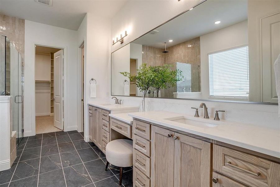 Bathroom with dual sink vanity, tile floors, and walk in shower