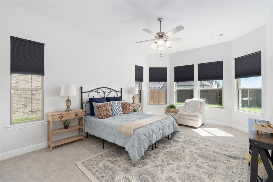 Carpeted bedroom featuring ceiling fan