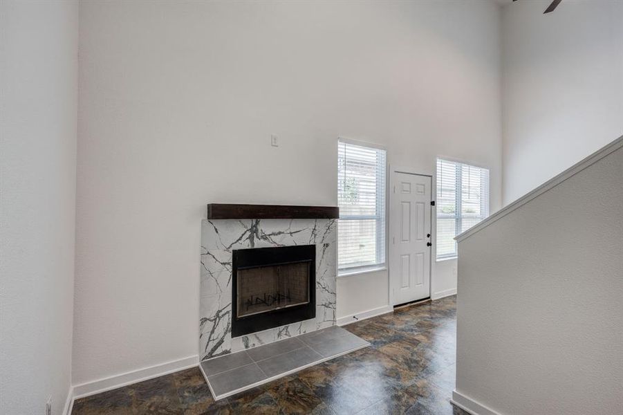 Unfurnished living room with a high end fireplace and dark tile patterned floors