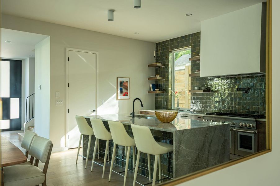 An exquisite waterfall stone island anchors this gourmet kitchen complete with premium built-in appliances. An exquisite waterfall stone island anchors this gourmet kitchen complete with premium built-in appliances.