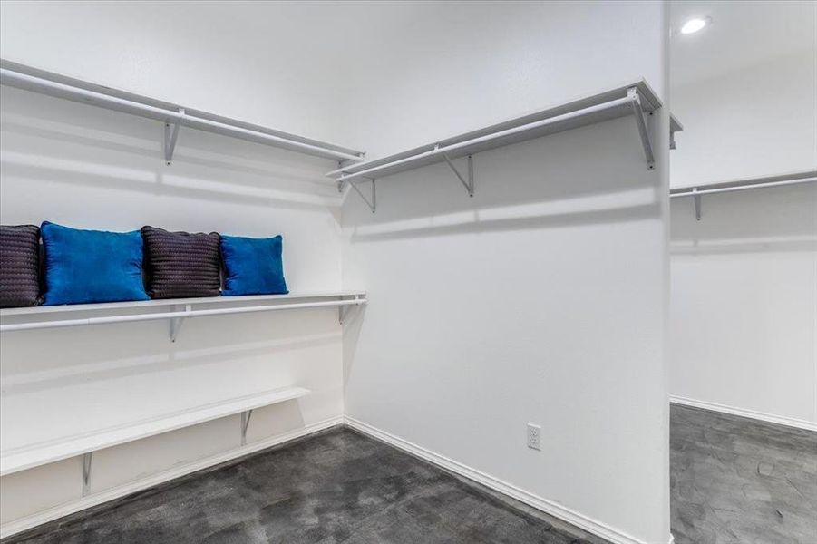 Spacious closet with white walls and dark grey flooring
