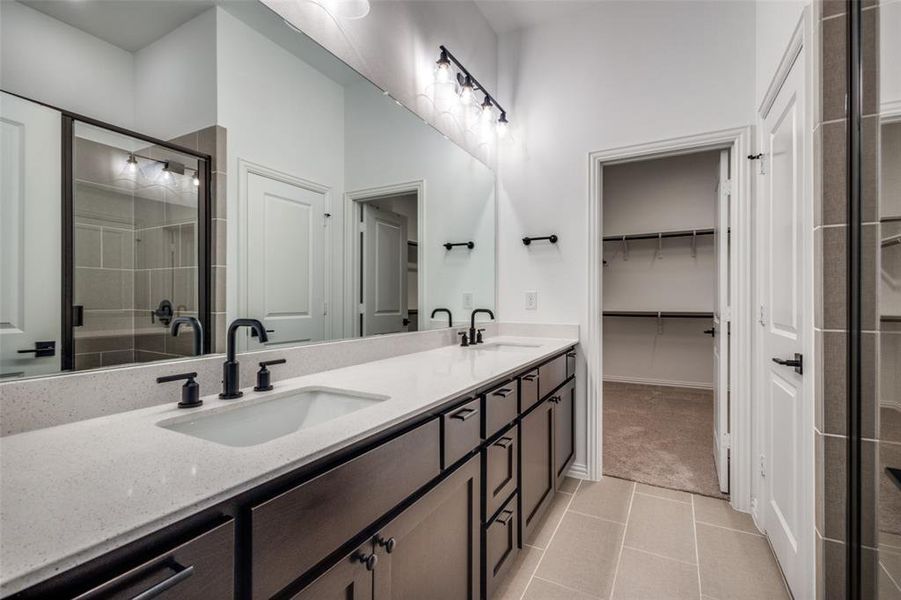 Bathroom featuring tile patterned flooring, vanity, and a shower with shower door