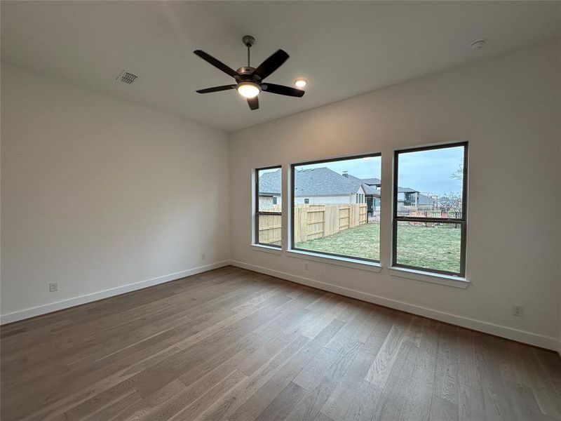 Primary Bedroom features an oversized window to enjoy the beautiful trees that line the property.