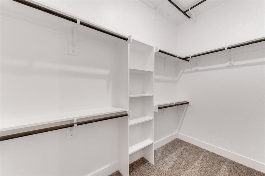 Spacious closet with light colored carpet Spacious closet with light colored carpet
