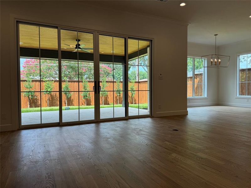 Spare room with wood-type flooring, a notable chandelier, and ornamental molding