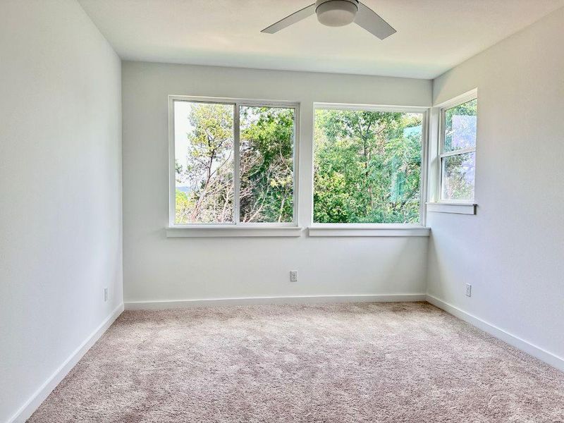 A spacious chamber with soft carpeting and broad windows providing verdant outdoor vistas. A spacious chamber with soft carpeting and broad windows providing verdant outdoor vistas.