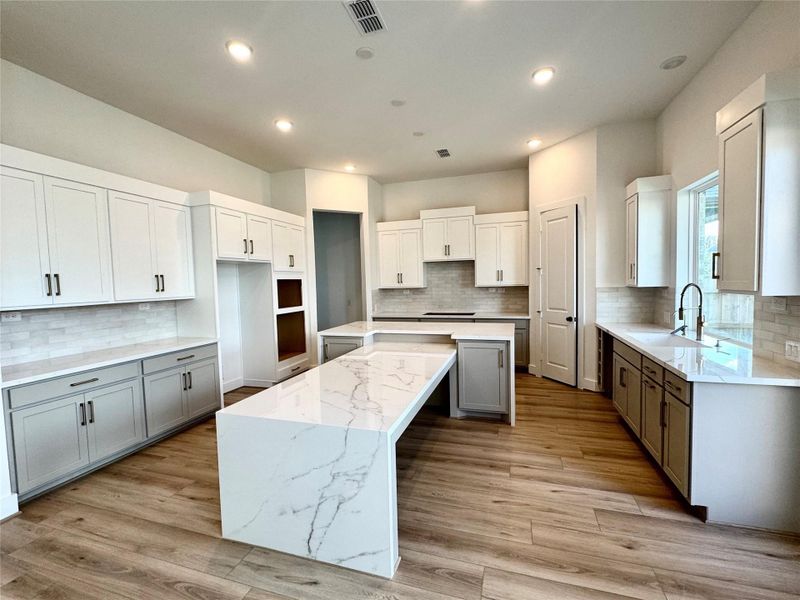 Additional view of the kitchen which offers an abundance of cabinets and a unique breakfast bar.