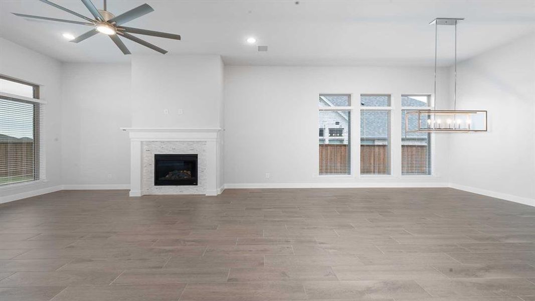 Unfurnished living room with ceiling fan and light wood-type flooring