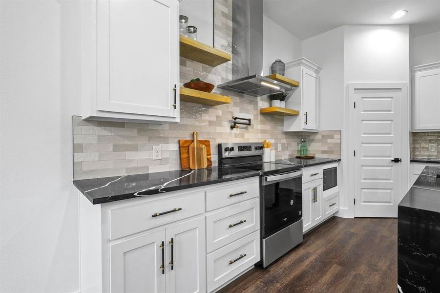 Kitchen featuring stainless steel electric range oven, ventilation hood, white cabinetry, decorative backsplash, and dark wood-type flooring