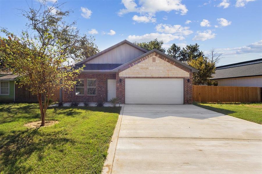 Single story home featuring concrete driveway, brick siding, board and batten siding, and an attached garage Single story home featuring concrete driveway, brick siding, board and batten siding, and an attached garage