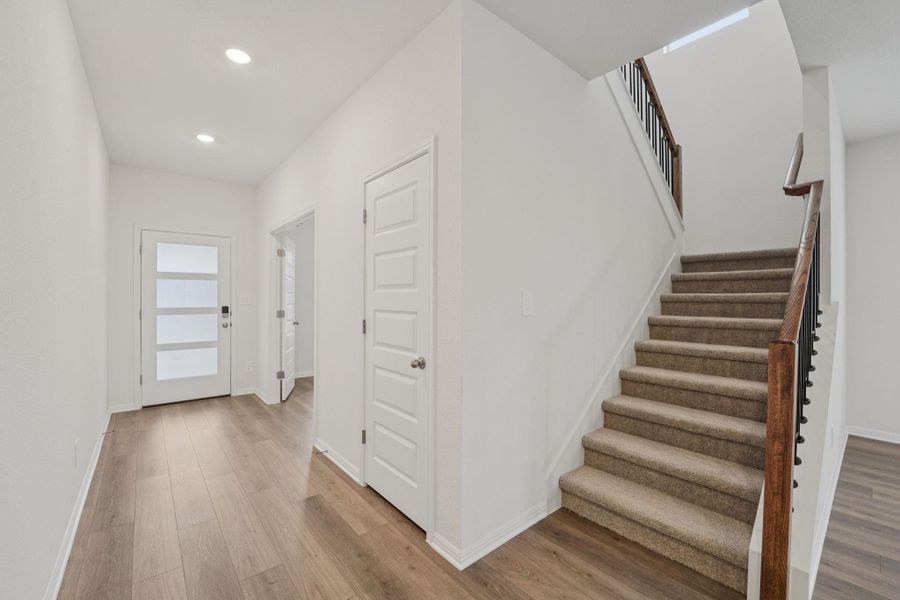 Foyer with light wood-type flooring, stairs, and recessed lighting