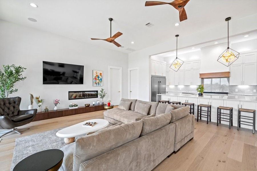 Modern comfort meets clean design in this spacious living area, featuring custom lighting, a sleek fireplace, and a seamless flow into the gourmet kitchen. Ideal for cozy nights in or entertaining guests at your Canyon Lake retreat.