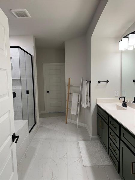 Bathroom featuring marble finish floor, vanity, visible vents, and a stall shower