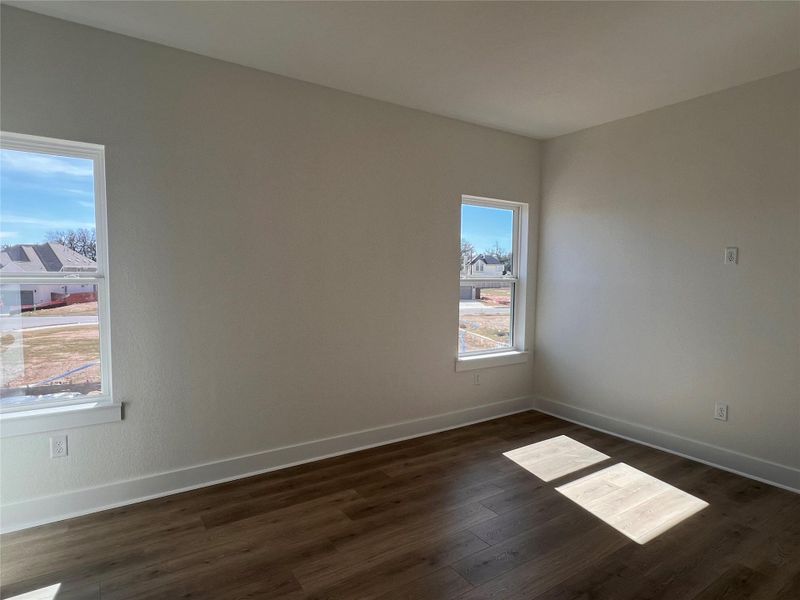 Unfurnished room with baseboards and dark wood-style flooring
