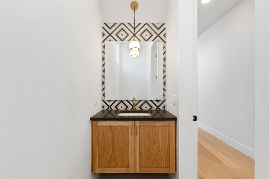 Bathroom featuring vanity, baseboards, and wood finished floors