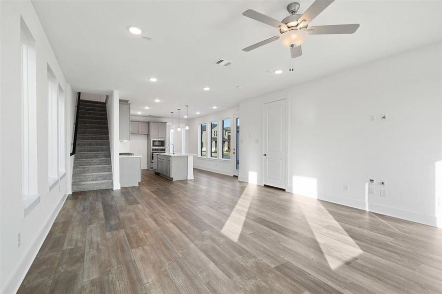 Unfurnished living room featuring ceiling fan and wood-type flooring