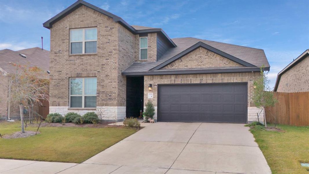 View of front of house with a garage and a front lawn